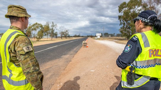 Australian Army soldier Lance Corporal Jacob Binns (left) from the 6th Battalion, Royal Australian Regiment, and Senior Constable Megan Down from the Queensland Police Service at a police control point near Hebel on the Queensland/NSW border during Operation COVID-19 Assist.