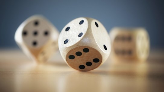 Rolling three dice on a wooden desk die dice?