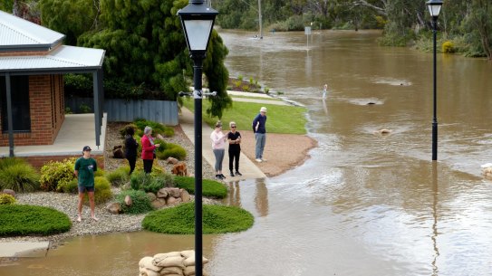 Residents watch the flood roar down Campaspe Esplanade in Echuca.