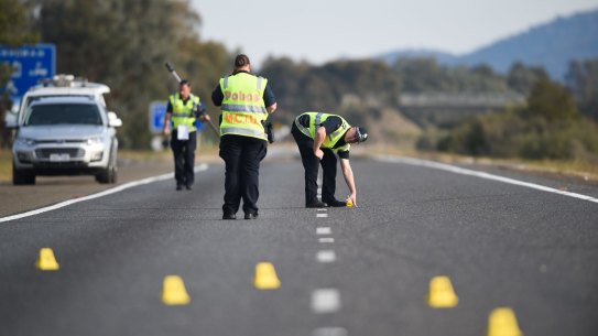 Victoria Police members investigate a crash on the Hume Freeway in 2017.