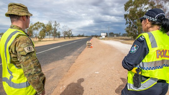 A soldier and police officer patrolling Queensland's border with NSW near Hebel.