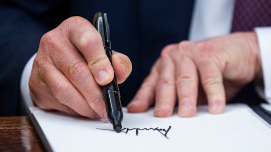 US President Donald Trump signs executive orders in the Oval Office of the White House in Washington, DC.
