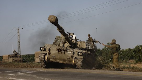 Israeli security forces aboard a self-propelled canon move towards the border with Gaza outside Sderot, Israel.