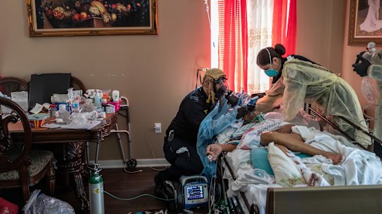 Medics intubate a gravely ill patient with COVID-19 symptoms at his home in New York in April 2020.