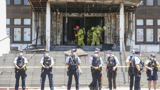 Firefighters responding at the fire-damaged front entrance of Old Parliament House following a protest, in Canberra on Thursday 30 December 2021. fedpol Photo: Alex Ellinghausen