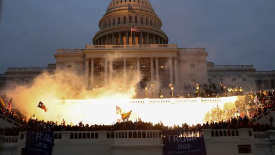 An explosion caused by a police munition is seen while supporters of US President Donald Trump storm the Capitol building. 