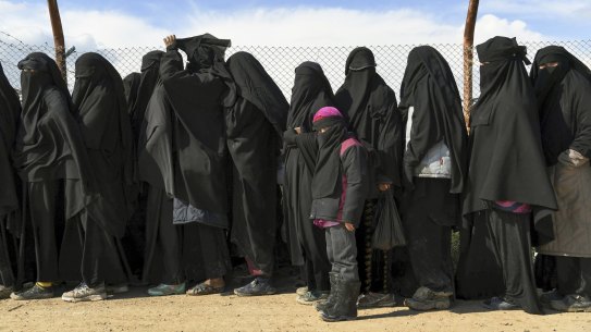 Foreign IS wives and children line up in the Al Hawl camp in Syria to be taken to shops in the camp in 2019.