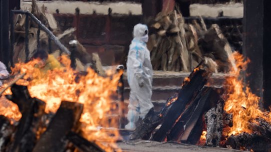 A man wearing PPE performs the last rites to his relative who died of the Covid-19 coronavirus disease at a crematorium on April 20, 2021 in New Delhi, India. Covid-19 cases are spiralling out of control in India, with daily infections approaching 300,000, according to health ministry data, bringing the nationwide tally of infections to almost 14 million. The latest wave has already overwhelmed hospitals and crematoriums. 