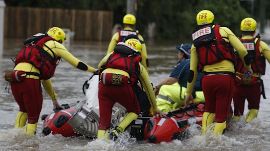 Queensland Fire and Emergency Services crew members are seen in floodwaters in Hermit Park, Townsville, Sunday, February 3, 2019. (AAP Image/Andrew Rankin) NO ARCHIVING