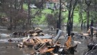 The village of Mogo, after being badly hit by fires, now finds some of the houses that burnt down, are flooded by the local creek.