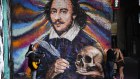A girl plays guitar and a couple kiss under a mural depicting William Shakespeare on the south bank of river Thames, as the capital is set to reopen after the lockdown due to the coronavirus outbreak, in London, Saturday, July 4, 2020. England is embarking on perhaps its biggest lockdown easing yet as pubs and restaurants have the right to reopen for the first time in more than three months. In addition to the reopening of much of the hospitality sector, couples can tie the knot once again, while many of those who have had enough of their lockdown hair can finally get a trim. (AP Photo/Alberto Pezzali)