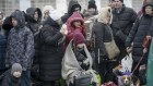 People who left Ukraine, wait for a bus to take them to the train station in Przemysl, at the border crossing in Medyka, Poland.