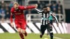 Swansea City's Mike van der Hoorn, left, and Newcastle United's Christian Atsu battle for the ball during the English Premier League soccer match against Swansea City at St James' Park, Newcastle, England, Saturday Jan. 13, 2018. (Owen Humphreys/PA via AP)