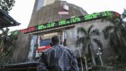 A man looks up at an electronic ticker board that indicates stock figures at the Bombay Stock Exchange (BSE) in Mumbai, India, on Friday, Jan. 27, 2017. While economists urge more investment in roads, ports and railways when the Indian government presents its budget Feb. 1, and maybe even direct cash transfers to boost consumption, a splurge carries the risk of a rating downgrade. Photographer: Dhiraj Singh/Bloomberg .