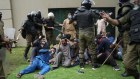 Police detain supporters of former prime minister Imran Khan during a search operation in his home in Lahore. 