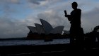 A tourist takes a photo in front of the Sydney Opera House. A rebound in travel has not been reflected in the share price of local travel companies.