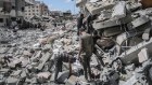 Palestinians searching through piles of rubble in central Gaza. 