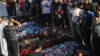 Mourners gather around covered bodies at the Shifa Hospital in Gaza City.