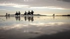Horses are ridden along the beach in Portmarnock, County Dublin, Ireland, Monday, Dec. 30, 2019. (AP Photo/David Goldman)