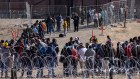 Migrants wait in line to be processed at the US-Mexico border in May.