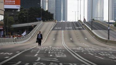 A man walks alone on a empty road near the Legislative Council after protesters continue to protest against the extradition bill in Hong Kong. 