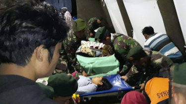 Indonesian soldiers tend to a woman injured in the earthquake at a makeshift hospital in Lombok.