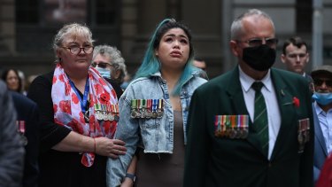 Megan Rull, second from left, whose partner took his own life last year, is comforted at the Remembrance Day service in Martin Place on Thursday.
