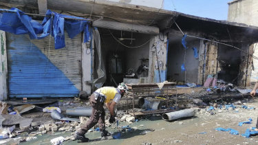 A White Helmet civil defence member works outside damaged shops after shelling hit a street in the town of Ehssem, southern Idlib, on Friday. 
