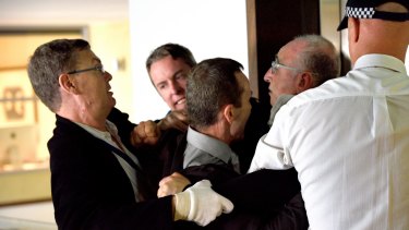 Michael Teplitsky struggles with federal police during the May 16 raid on his office.