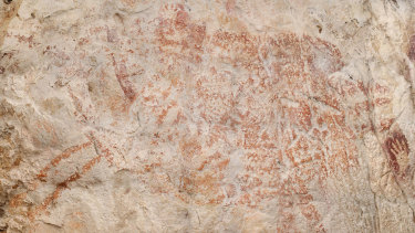 A composite image from the book Borneo, Memory of the Caves shows the world's oldest figurative artwork in a limestone cave in Borneo. Scientists say the red silhouette of a bull-like beast, upper left, is the oldest known example of animal art.
