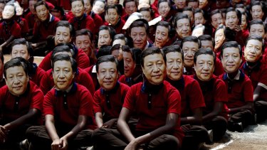 Indian school children wear face masks of Chinese President Xi Jinping to welcome him on the eve of his visit in Chennai, India. 