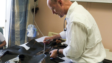 Chris Lowe, director of the Shark Lab at California State University, Long Beach, analyses the mangled wetsuit Maria Korcsmaros was wearing when she was attacked. 