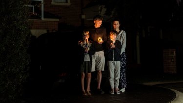 Paul and Maria Hanson and their children Tom and Jack observe a minute silence in their driveway in Melbourne.