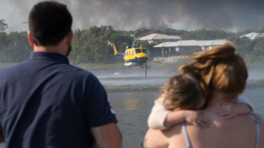 A helicopter taking on water at Peregian Spring Golf Course to water-bomb the Sunshine Coast bushfires on Tuesday.
