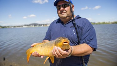 Charlie Diedo catches carp on the shore of Lake Burley Griffin in Canberra.