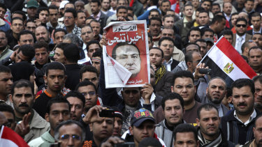 February, 12, 2011:  A protester holds up a sign that reads 'Finally he steps down' in Tahrir Square, Cairo.