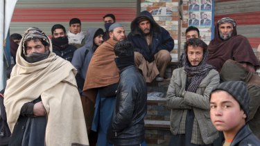 Afghan bystanders watch the aftermath of an attack in Kabul, Afghanistan, on January 15. All sides are hopeful a solution to the war is near.