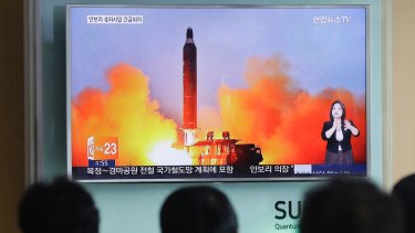 People watch a TV news channel airing an image of North Korea's ballistic missile launch in March last year.