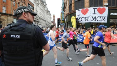 An armed police officer stands at the start of the Great Manchester Run in central Manchester after the bombing which killed 22 people.