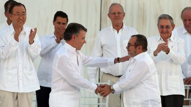 Colombian President Juan Manuel Santos, front left, and the top FARC commander, Rodrigo Londono, known by the alias Timochenko, shake hands after signing the 2016 peace agreement to end 50 years of conflict.