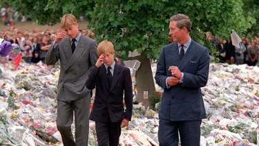 Princes William and Harry with their father Prince Charles walk among floral tributes in the wake of Diana's death. 