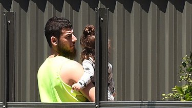 Mehmet Biber carrying his daughter in the backyard of the family home in Merrylands.
