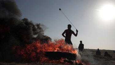 A Palestinian protester hurls stones toward Israeli soldiers during a protest near the Gaza Strip border with Israel on Saturday.