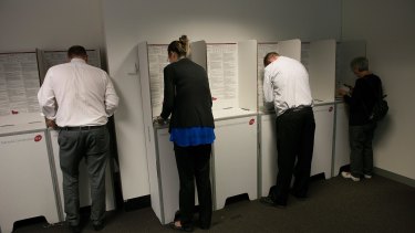 Voters lodge early votes at an Early Voting Centre ahead of the Victorian state election on November 25, 2014 in Melbourne. 