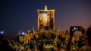 In more placid times: people gather to pray and take photos in front of a portrait of King Bhumibol at Sanam Luang park in December 2019 in Bangkok, Thailand. 