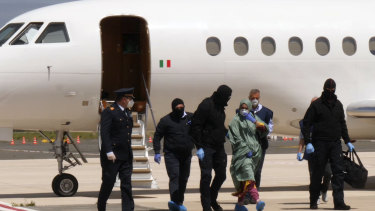 Silvia Romano, covered in protective gear against the risk of COVID-19, walks on the tarmac after landing at Rome's Ciampino airport.