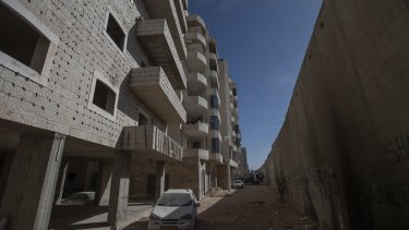 A building under construction in the Kufr Aqab neighbourhood in Jerusalem, divided from the rest of the city by Israel's security barrier, seen on the right.