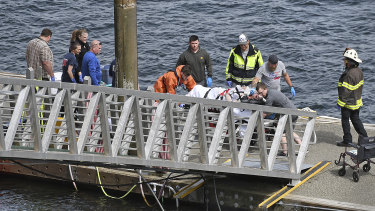Emergency response crews transport an injured passenger to an ambulance at the George Inlet Lodge docks in Ketchikan, Alaska, on Monday.