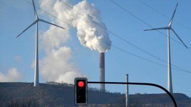 A coal-burning power plant steams behind wind generators in Gelsenkirchen, Germany.