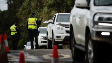 SMH NEWS: Commuters are stopped by police at a Queensland-NSW border checkpoint.